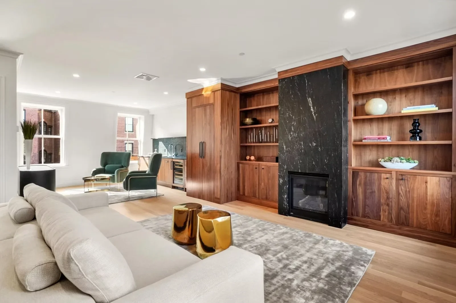 Custom walnut cabinetry, black marble fireplace, built-in shelving, hardwood floors, and recessed lighting in modern living room